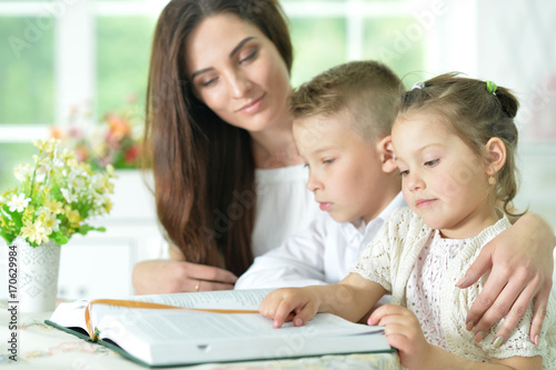 Mother and children reading book