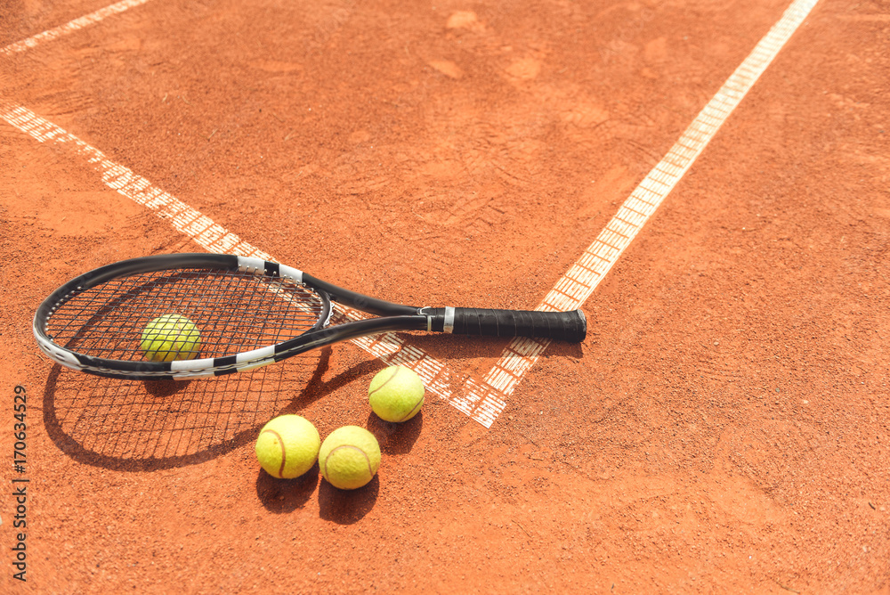 Racquet beside round objects on court