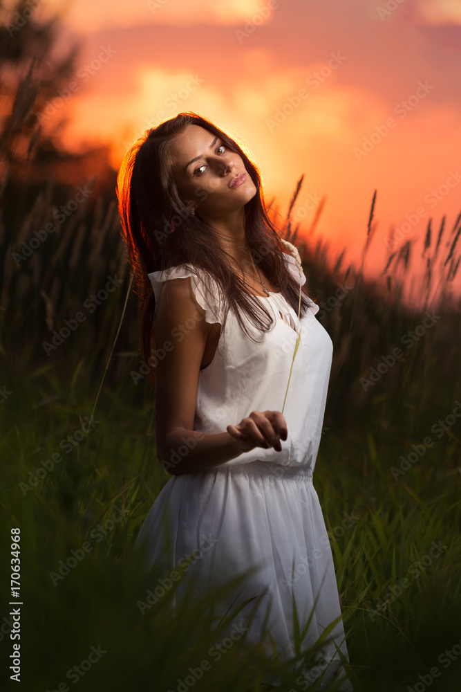 Obraz premium Beautiful woman posing at sunset