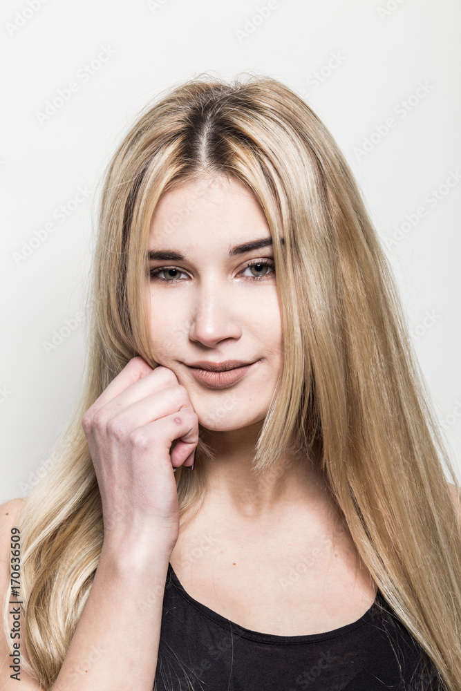 Close-up portrait of a young beautiful blonde girl on a light background. A woman with different emotions on her face. Close-up portrait of a young beautiful blonde girl on a light background. A woman with different emotions on her face.