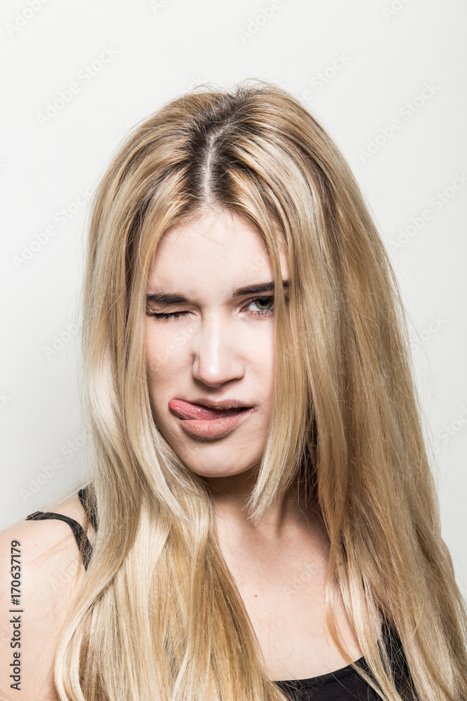 Close-up portrait of a young beautiful blonde girl on a light background. A woman with different emotions on her face. Close-up portrait of a young beautiful blonde girl on a light background. A woman with different emotions on her face.