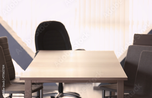 Empty wooden table and chairs in conference room