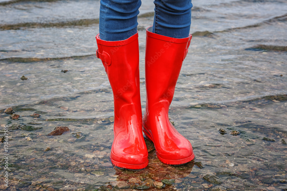 Young woman in red rubber boots outdoors Young woman in red rubber boots outdoors