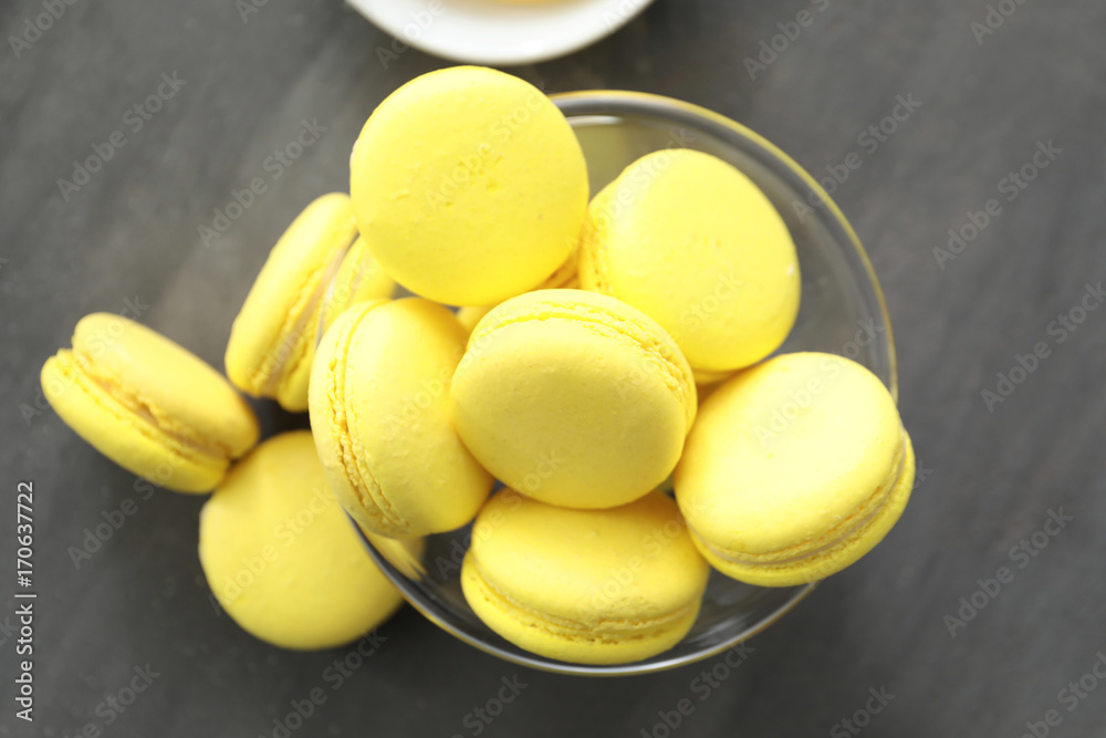 Glass bowl with tasty homemade lemon macarons on table Glass bowl with tasty homemade lemon macarons on table