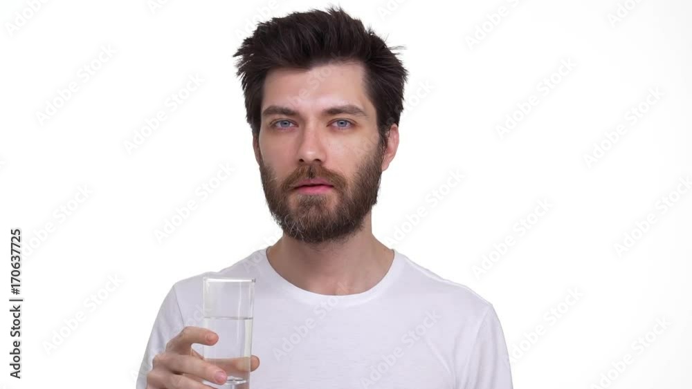 Young man drinking water from a glass smiling Young man drinking water from a glass smiling