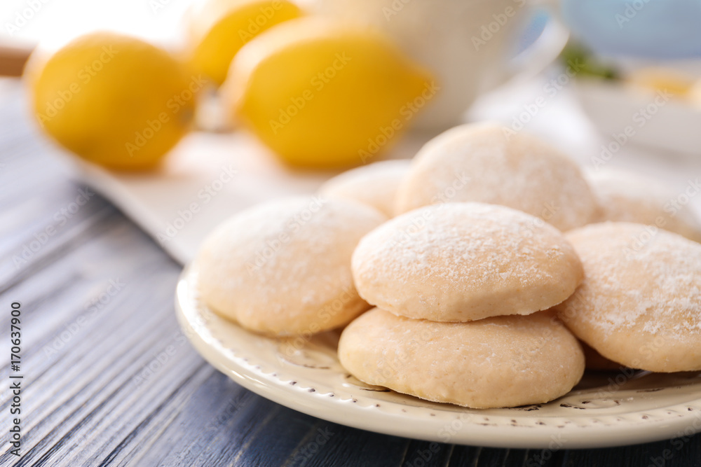Plate with homemade lemon cookies on wooden table, closeup