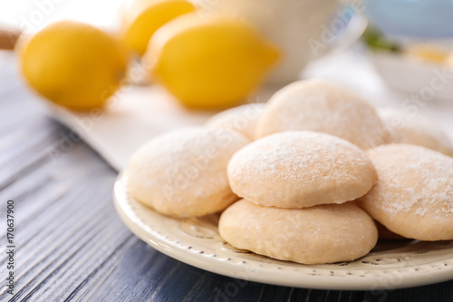 Plate with homemade lemon cookies on wooden table, closeup