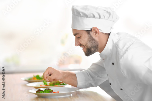 Young male chef decorating ...