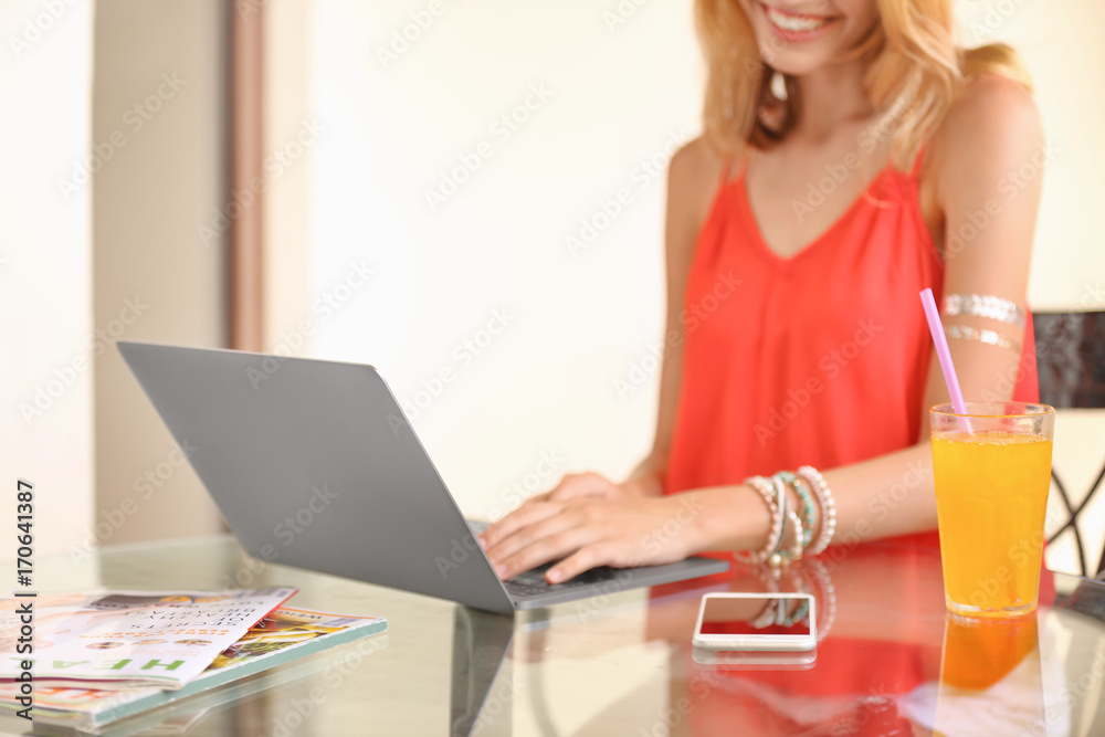 Beautiful young woman with glass of lemonade and laptop in cafe Beautiful young woman with glass of lemonade and laptop in cafe