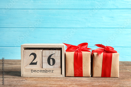 Calendar with date and gift boxes on color background. Christmas concept