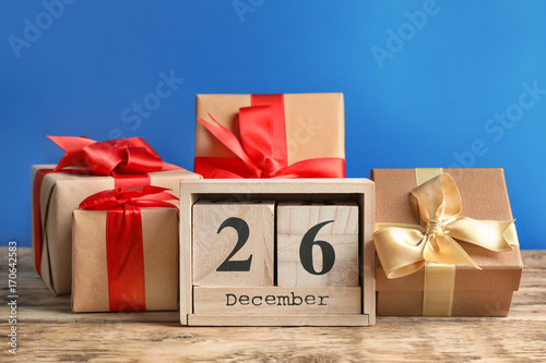 Calendar with date and gift boxes on color background. Christmas concept