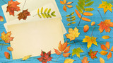 Autumn composition. Fall colorful leaves framed paper on wooden background. Top view 