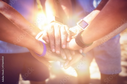 Fotografi Mid section of athletes forming hands stack