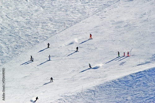 Skiers and snowboarders riding on a ski slope in Sochi mountain resort snowy winter photo