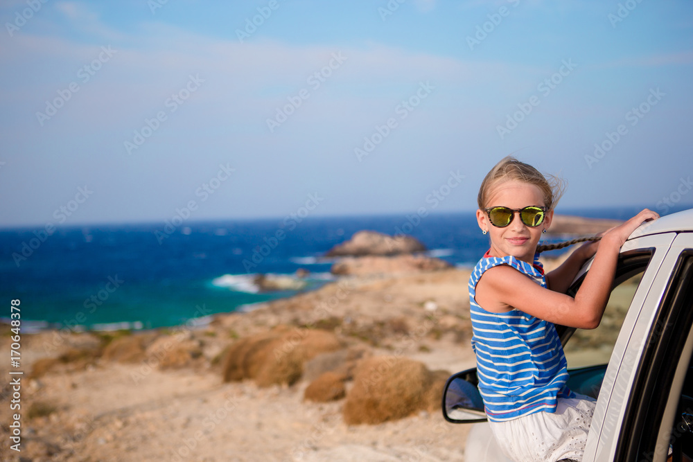 Little girl on vacation travel by car with beautiful view