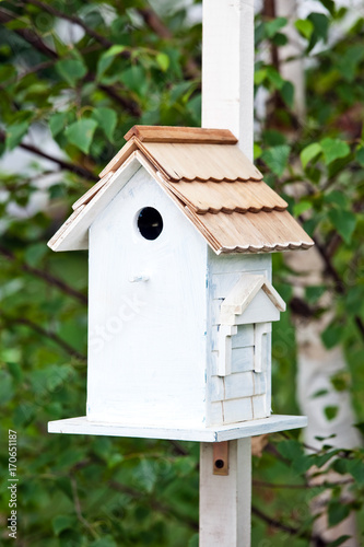 Blue birdhouse on the tree. Wooden house for birds among the leaves