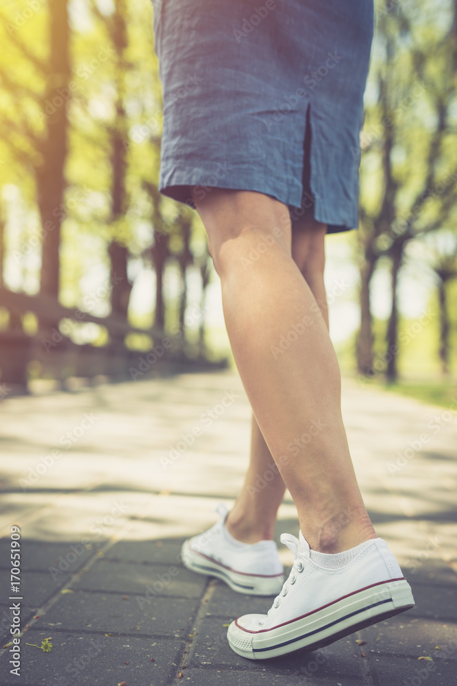 Walking. Woman walking in park, wearing the canvas shoes