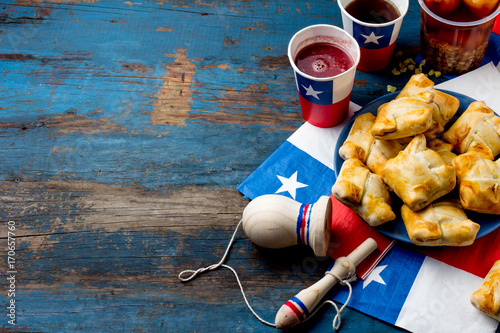 Chilean independence day concept. fiestas patrias. Chilean typical dish and drink on independence day party, 18 september. Mini empanadas, mote con huesillo, wine with toasted flour, chicha and photo