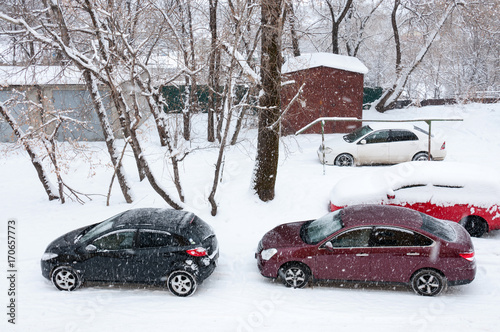 Winter, cars stand in the yard, snow outside