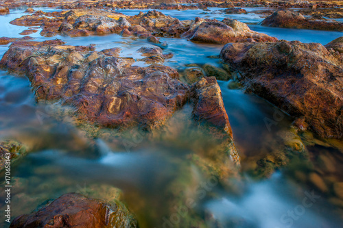 Silk effect on the water in the river Tinto with stones of color bronze  near the village of Niebla  in Huelva