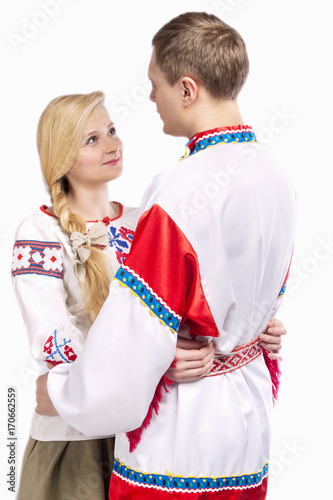 Fashion Ideas. Portrait of Loving Embraced Caucasian Couple in National Belarussian and Russian Decorated Costumes. Against White Background.