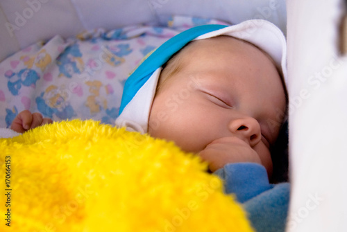 Obraz na płótnie Portrait of sweet sleeping newborn baby in cap under yellow blanket w salonie