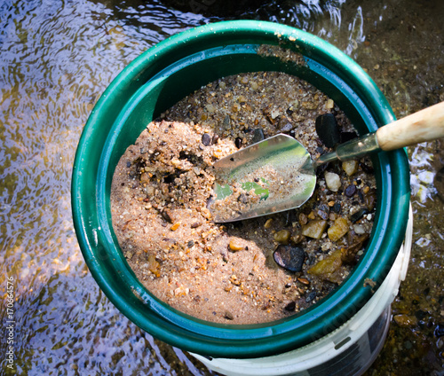 Sifting and classifying mineral rich soil in gold panning classifier pan. Fun outdoor sport adventure of prospecting and panning for gold.