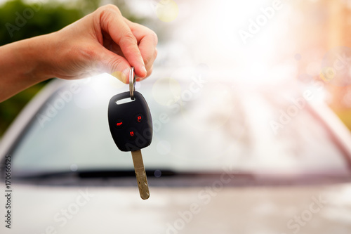 The hand of a woman holding a car key.