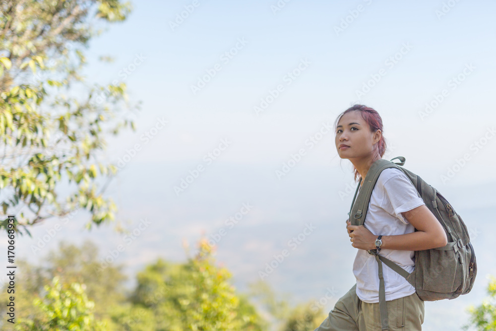 Young Traveler with map backpack relaxing outdoor with forest rocky mountain on background Summer vacations and Lifestyle hiking concept,Vintage style
