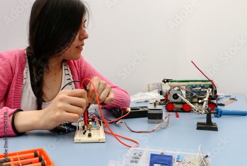 Young electronics student learning about basic PCB connection and robotics photo