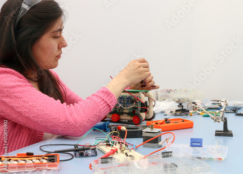 Young engineer student learning robotics and electronics photo