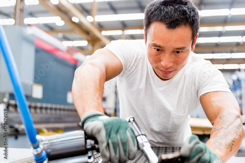 Asian worker in production plant on the factory floor