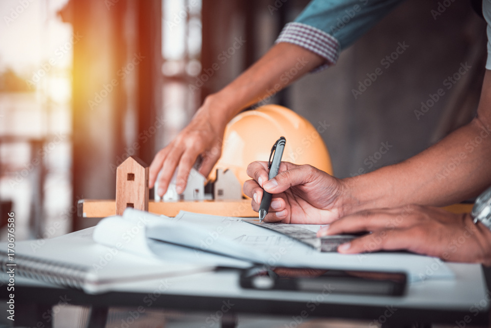 architect man working with blueprints,engineer inspection in workplace for architectural plan,sketching a construction project ,selective focus.