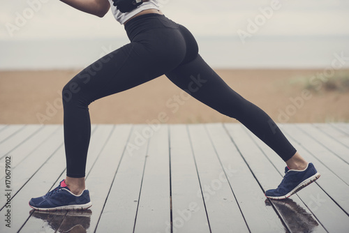 Lower body of a slim sporty girl exercising outdoors on a beach