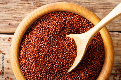 The texture of raw red quinoa macro in a wooden bowl. Horizontal top view