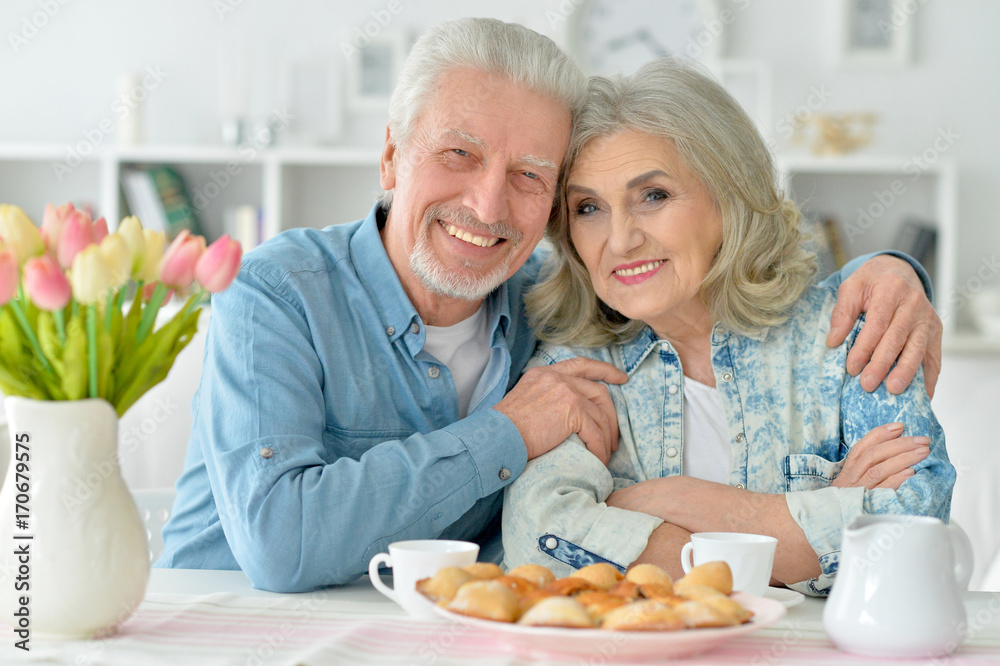 senior couple drinking tea with cookies