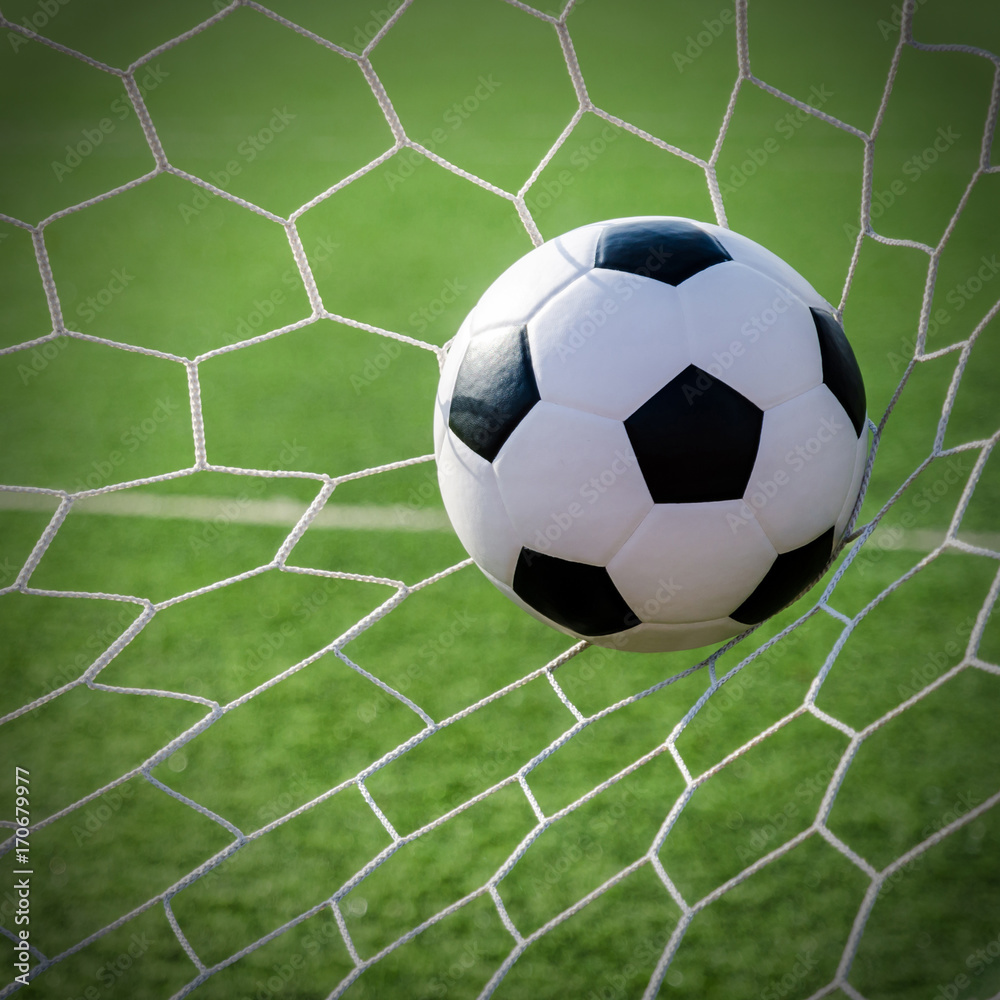 Soccer football in Goal net with green grass field. Soccer football in Goal net with green grass field.