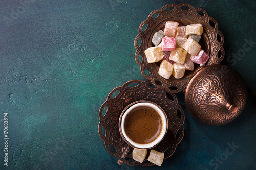 Traditional turkish coffee  and turkish delight on dark green wooden background. flat lay