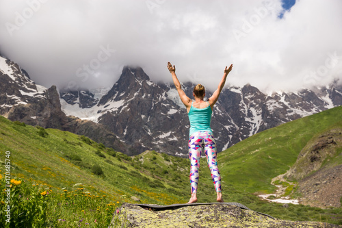 Young woman doing yoga in beautiful mountains. Nice view