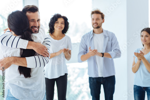 Delighted cheerful man hugging a woman