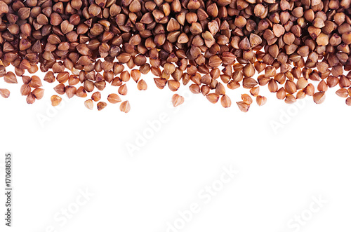 Brown buckwheat as decorative border isolated on white background. Top view, closeup.