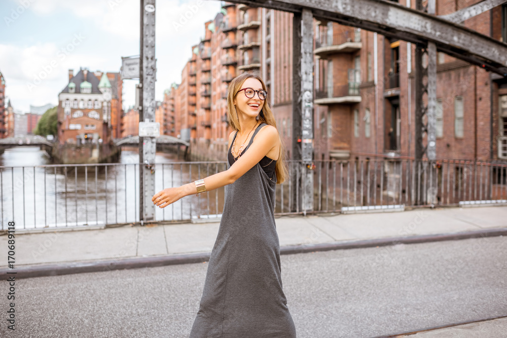 Lifestyle portrait of a stylish business woman walking on the iron bridge in Hamburg, Germany