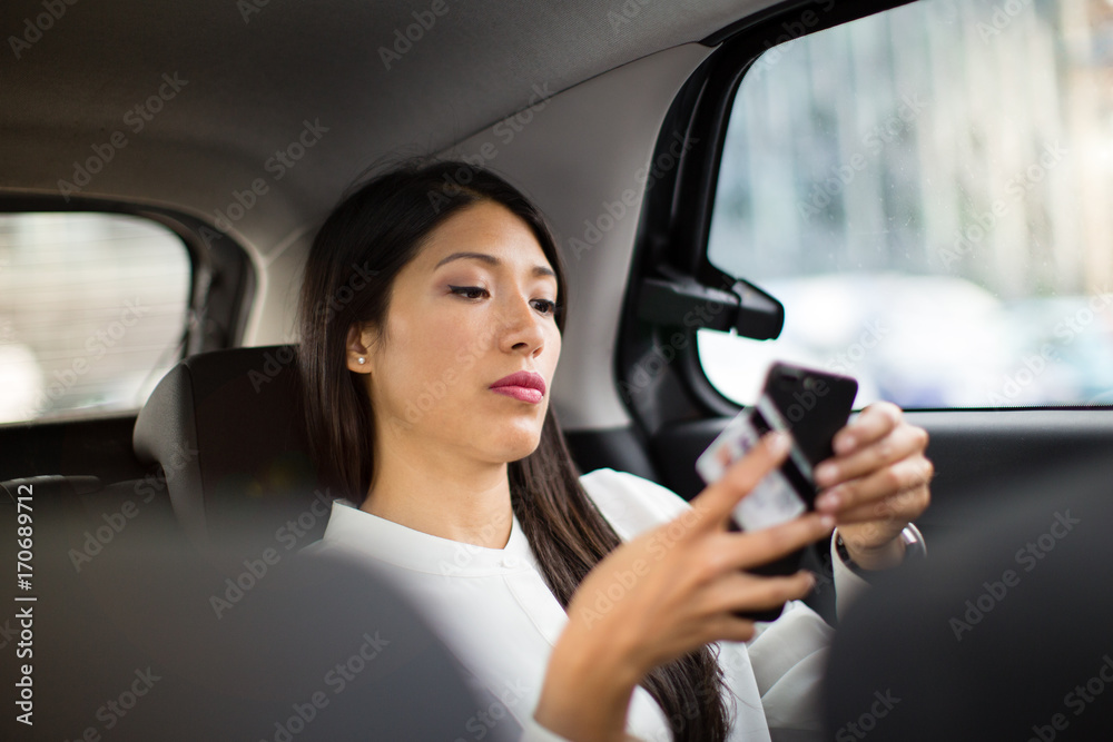 Businesswoman paying via app for taxi cab ride Businesswoman paying via app for taxi cab ride