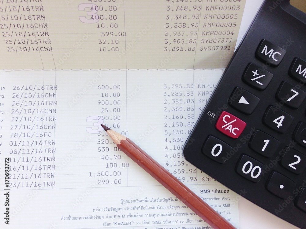 Business, finance, investment or accounting concept : Calculator and saving account book or financial statement on office table Business, finance, investment or accounting concept : Calculator and saving account book or financial statement on office table