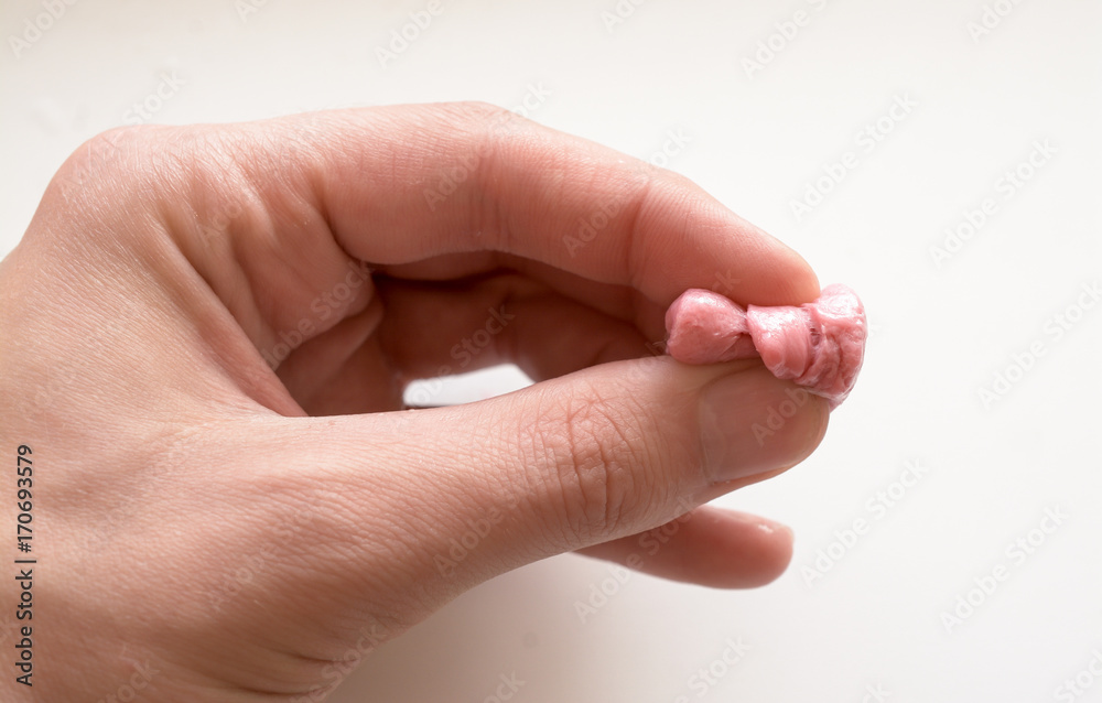 pink chewing gum and man hand isolated on white background pink chewing gum and man hand isolated on white background