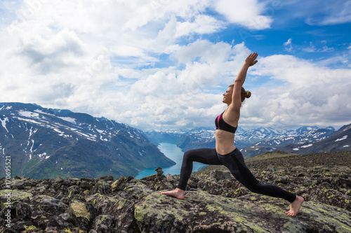 Young woman hiking on Besseggen. Happy girl enjoy beautiful lake and good weather in Norway.