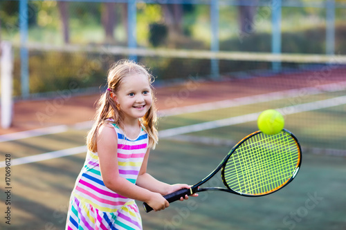 Child playing tennis on outdoor court