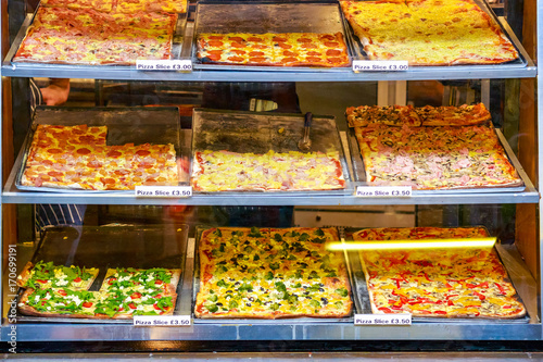 Variety of pizza slices on display for takeaway at Camden Market in London photo