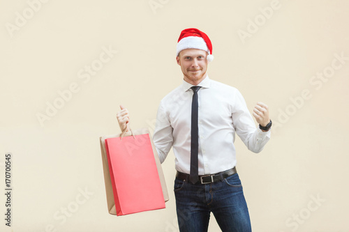Buy for best price in winter. Young adult and beard man in red santa hat ,happiness looking at camera.