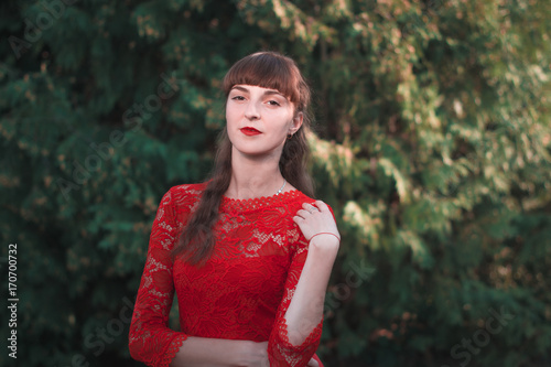 Portrait of a beautiful young girl in a red dress. photo
